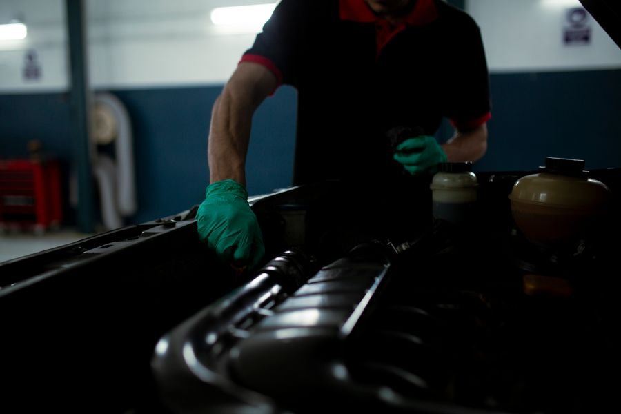Mecánico inspeccionando motor con aceite sintético
