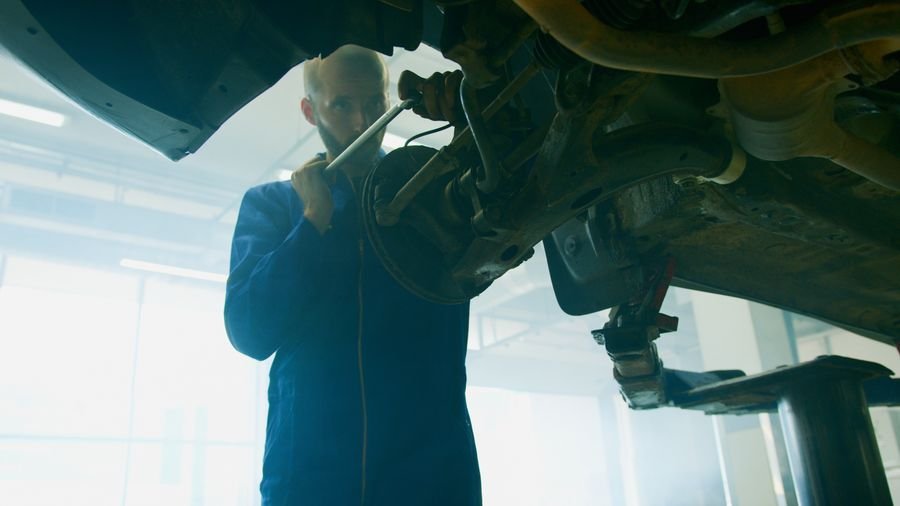 Mecánico reparando vehículo taller automotriz