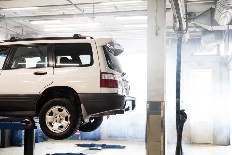 SUV blanco elevado en taller mecánico